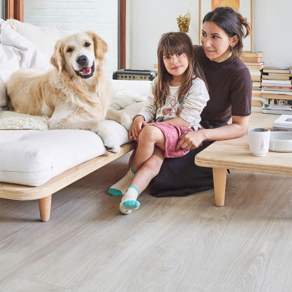 Sumeyya sits on the living room floor with her daughter. It is a Moduleo LayRed Laurel Oak 51230 Embossed luxury vinyl floor.